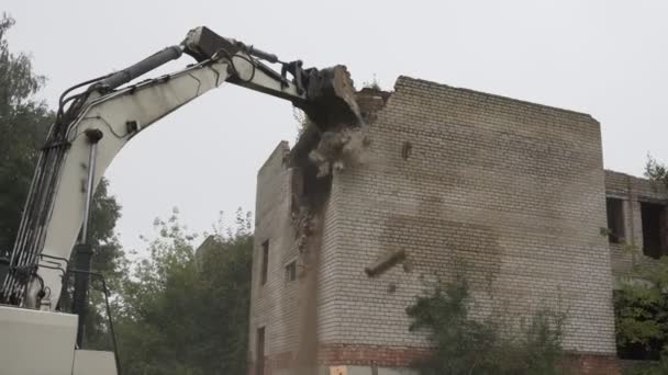 Buldożer z dużym dźwigiem rozbiórka opuszczonego budynku — Wideo stockowe