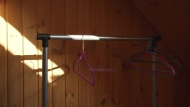 Boş kıyafetler, gardıroptaki metal askılarda asılı plastik askılar..
