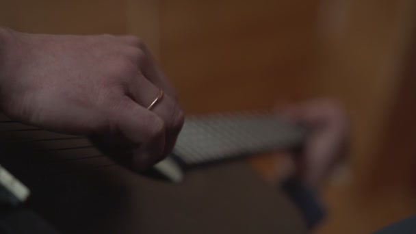 Hombre tocar la guitarra acústica con los dedos en el freatboard y cuerdas — Vídeo de stock