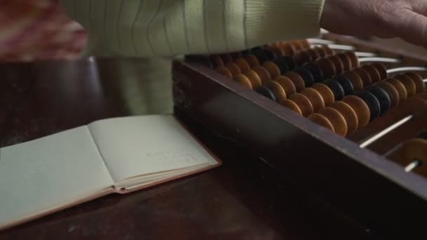 Starší účetní pracující s ročníkem abacus a psaní tužkou — Stock video