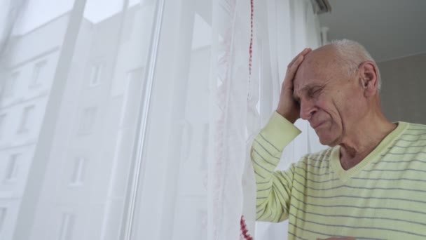 Gestresster älterer Mann hält Kopf mit Hand und hat Trauer Ausdruck. — Stockvideo