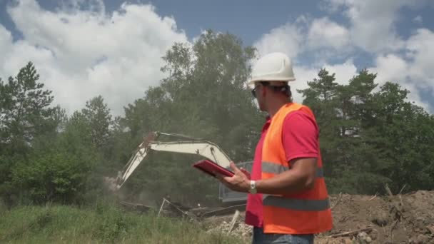 Manager dà istruzioni al conducente escavatore che raccoglie rifiuti di costruzione — Video Stock