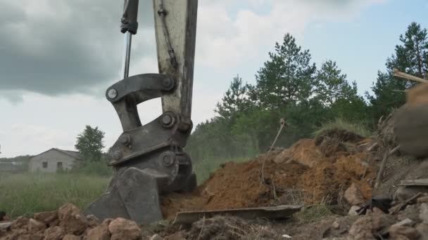 Az építőipari gépek gödröt ásnak. A kotrógép felszedi a talajt.. — Stock videók