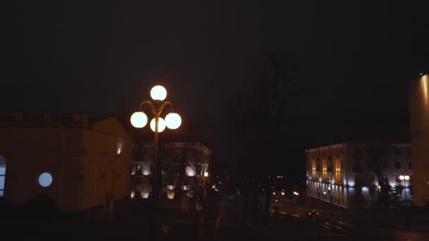 Rua da cidade vazia com lanterna vintage luminosa e carro de condução solitário — Vídeo de Stock