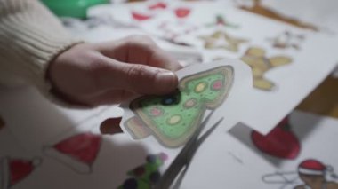 Elinde makasla genç bir kadın Noel ağacını kesiyor.