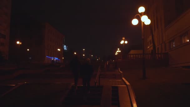 Pessoas do sexo masculino subindo na escada de concreto com corrimão no beco da cidade noite — Vídeo de Stock