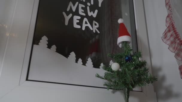 Feliz ano novo texto com letras de papel branco colando no vidro da janela — Vídeo de Stock