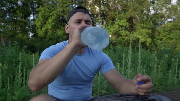 Reiziger het dragen van dop drinkwater uit grote plstic fles — Stockvideo
