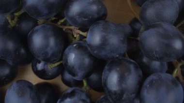 Tahta arka planda sulu böğürtlen dönüşümlü kırmızı üzüm demeti