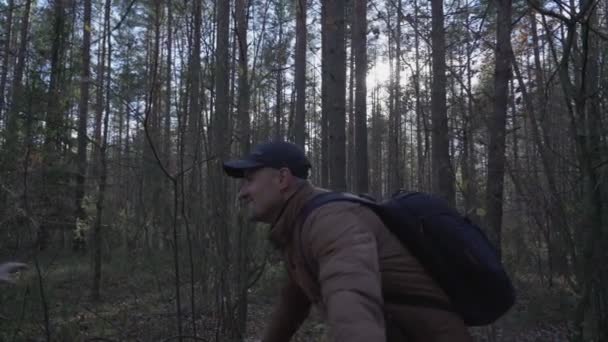 Vater mit Rucksack und kleiner Junge umarmen sich im Herbstwald — Stockvideo