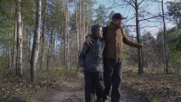 Adolescente com o pai vestindo roupas casuais andando na trilha da floresta — Vídeo de Stock