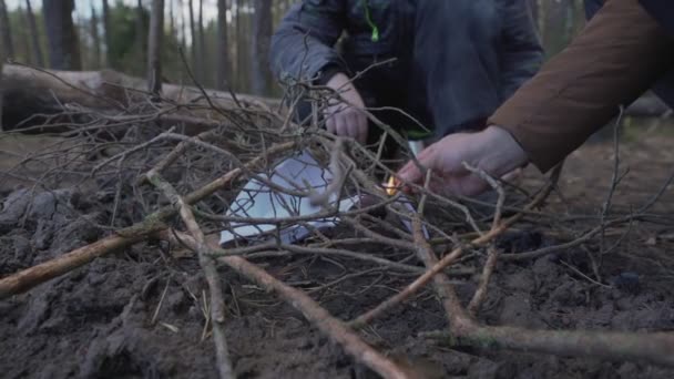 Père et fils accroupis près du feu de camp et allumer le feu avec match. — Video