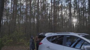 Mutlu aile babası ve oğlu, arabanın bagajından turist çantalarını alın.