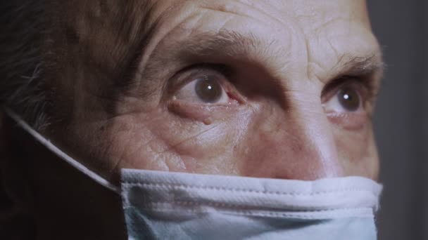Dicht zicht op gerimpeld gezicht van oudere man met beschermend masker — Stockvideo