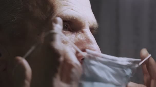 Chorym dojrzałym pacjentem noszącym medyczną maskę na twarzy z bliska. — Wideo stockowe