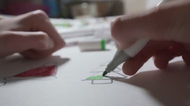 Elinde kalem tutan ve Noel ağacını boyayan liseli kız