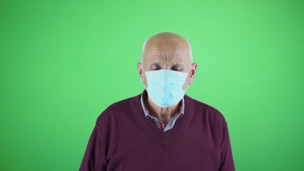 Хворий старший чоловік в масці для обличчя чхає з голови ізольовано на хромосі — стокове відео