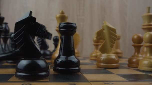 Свергнутая шахматная фигура черного короля лежит на шахматной доске. — стоковое видео