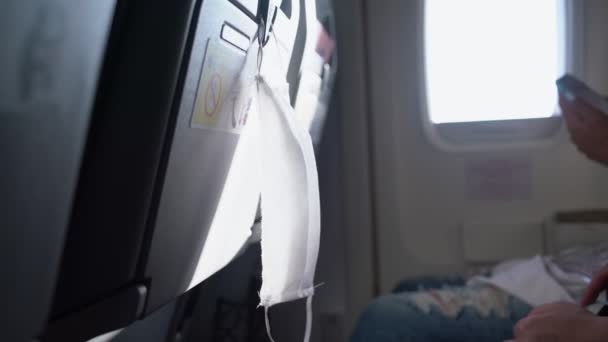 Topeng wajah medis putih tergantung di kursi penumpang pesawat — Stok Video