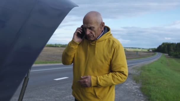 Man calls evacuation service looking under hood of car — Stockvideo