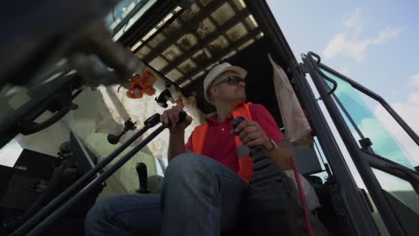 Erwachsener Fahrer steuert Hebel in Baggerkabine — Stockvideo