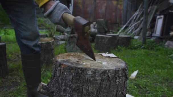 Elderly farmer chops wood in middle of yard in autumn — Video Stock