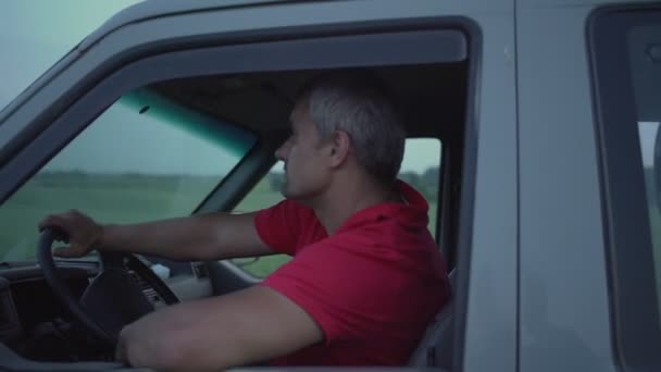 Conductor cansado de pelo gris sentado en el asiento de conducción durante el viaje por carretera — Vídeo de stock
