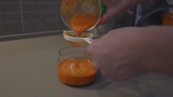 Female hand holding glass container with sea buckthorn puree — ストック動画