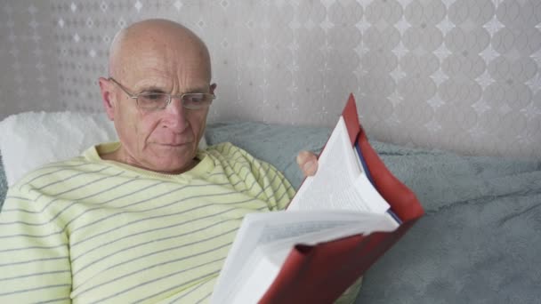 Ηλικιωμένος φαλακρός άντρας που φοράει γυαλιά ξαπλωμένος σε άνετο καναπέ — Αρχείο Βίντεο