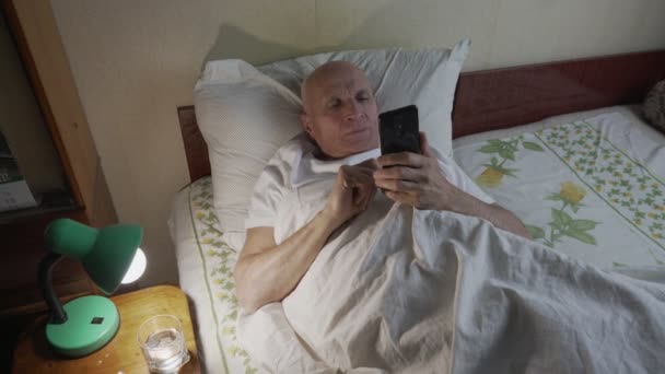 Maduro hombre de pelo gris que conecta con la familia utilizando el teléfono moderno — Vídeos de Stock
