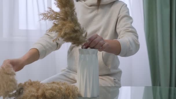 Hands of female florist creating bouquet of dried flowers at glass table — Stock Video