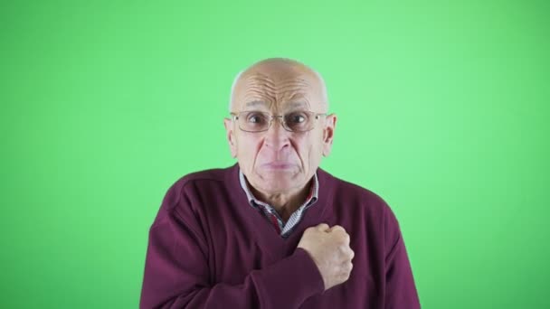Grumpy old man with glasses bangs his chest with his fist — Vídeo de Stock