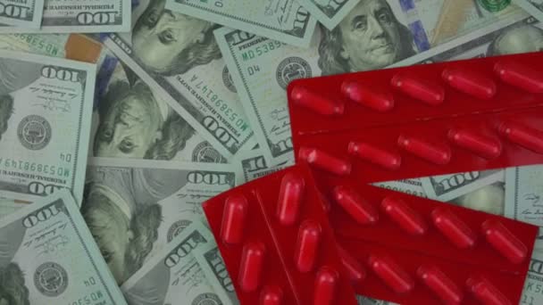 Red closed blister pack with pills rotate on us dollars background. — Vídeo de stock