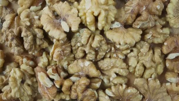 Pile of peeled half of walnut background rotate top close view. — Stockvideo