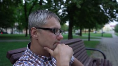 Adam zamanı kontrol eder bankta oturur ve havanın tadını çıkarır