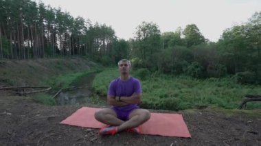 Orman ormanlarında meditasyon yapan bir adam