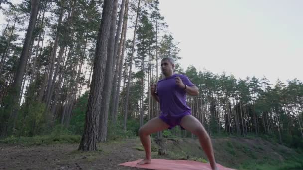 Mężczyzna stoi na pozycji i wykonuje ćwiczenia oddychania wellness — Wideo stockowe