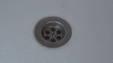 Su, paslanmaz beyaz çelik mutfak lavabosunun üstüne boşalıyor.