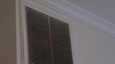 Çok kirli ve tozlu beyaz plastik havalandırma ızgarası beton duvara sabitlenmiş.