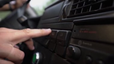 Sürücü el, siyah plastik retro arabanın üzerindeki havalandırma ızgarasını ayarlıyor.