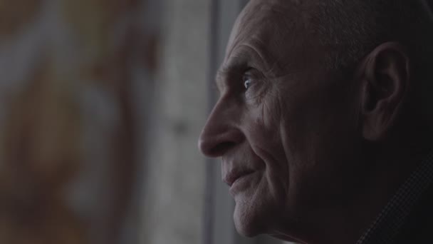 Дорослий чоловік дивиться через вікно будинку престарілих — стокове відео