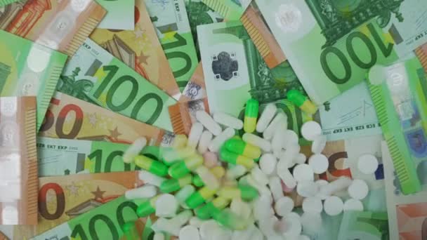 Różne tabletki medyczne i tabletki spadające na tle banknotów euro — Wideo stockowe