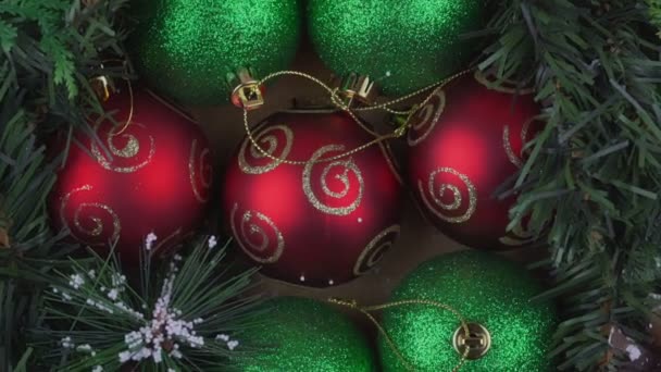 Bolas de Natal vermelho e verde com corda girar no fundo ramo árvore verde. — Vídeo de Stock