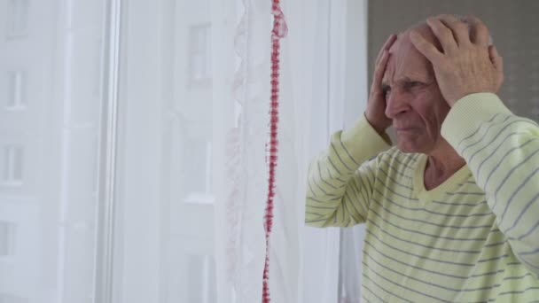 Oudere man houdt hoofd met handen en last van hoofdpijn — Stockvideo