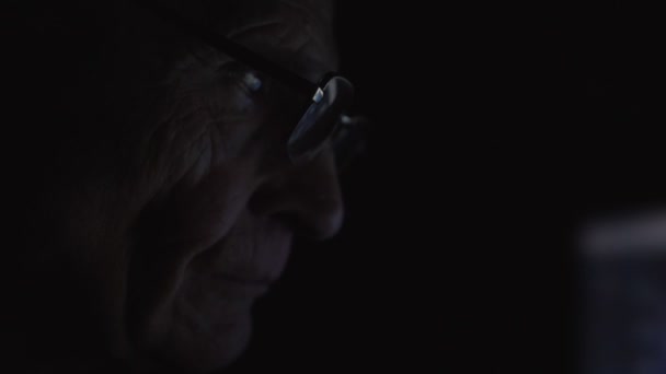 Grootvader zit aan tafel met computer en kijken om te controleren — Stockvideo