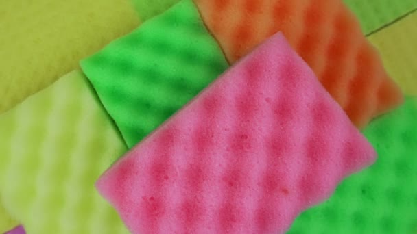 Esponjas multicolores para lavar platos giran en la pila vista superior de cerca. — Vídeo de stock
