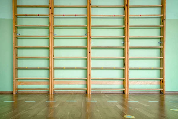 Beton duvarda tahta merdiveni olan boş spor salonu.