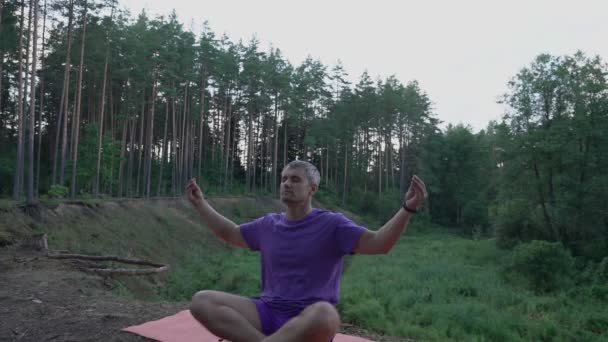 Osoba siedzi w pozycji lotosu na krawędzi klifu i medytuje — Wideo stockowe