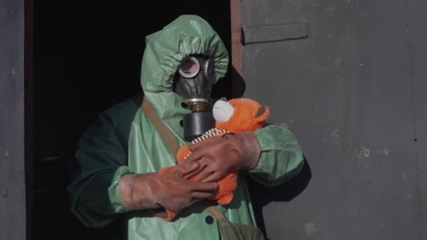 Person in protective clothes and gloves holds toy bear in hands — Stock Video