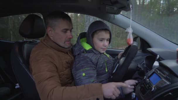 Vater zeigt seinem kleinen Sohn Autoarmaturenbrett. — Stockvideo